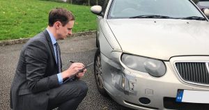 Insurance assessor inspecting a damaged car