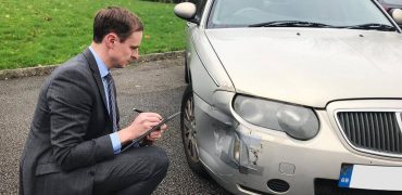 Insurance assessor inspecting a damaged car