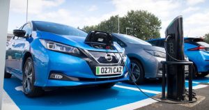 Blue car charging up at public charging point