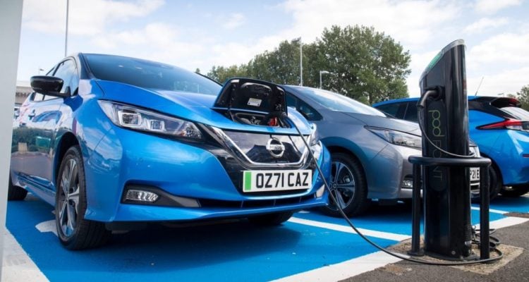 Blue car charging up at public charging point