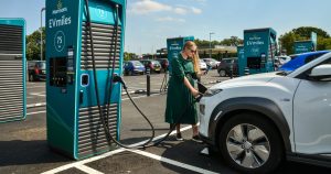 Woman charging her car at a supermarket