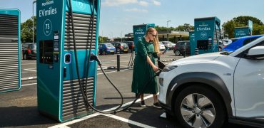 Woman charging her car at a supermarket