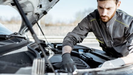 Mobile mechanic working on an engine