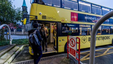 Passengers board one of the first of Manchester's franchised bus services