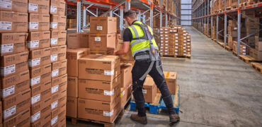 Worker wearing Hunic Exoskeleton lifting boxes