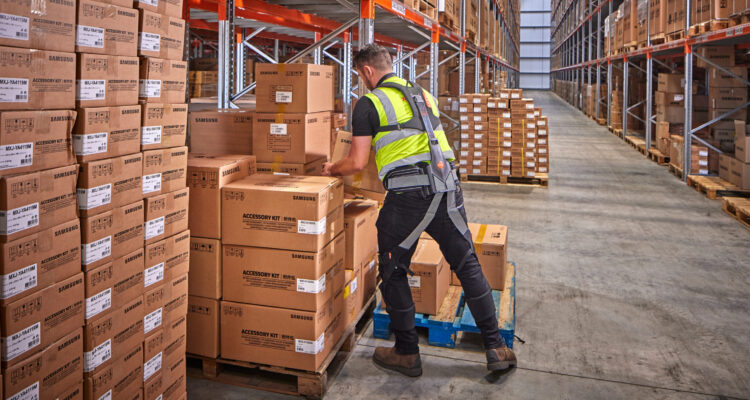 Worker wearing Hunic Exoskeleton lifting boxes