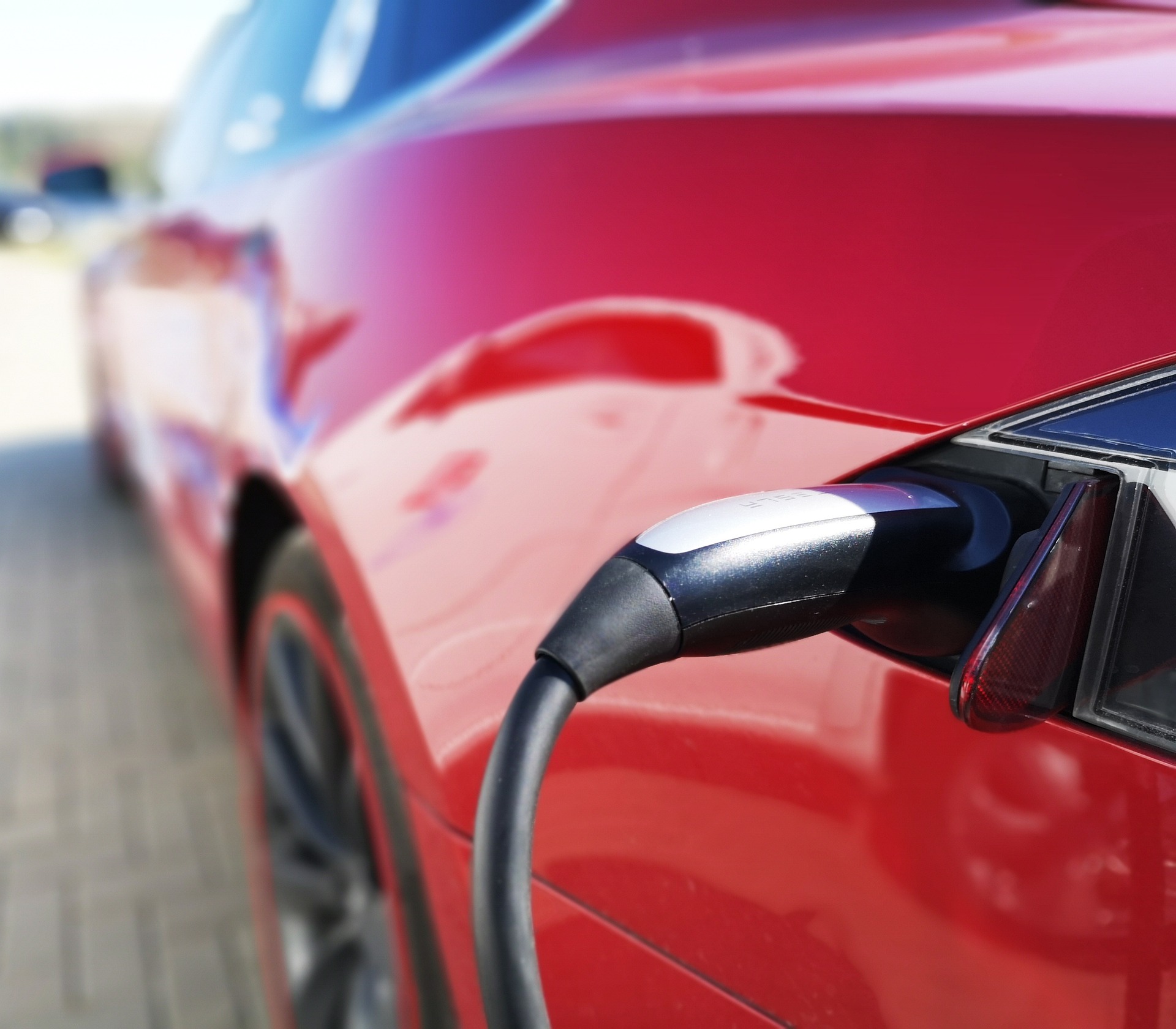 Red electric car being charged