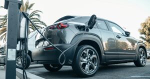 An electric car being charged, pay-per-mile