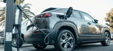 An electric car being charged, pay-per-mile