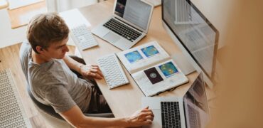 Person sitting infront of computor screens