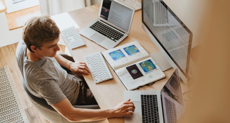 Person sitting infront of computor screens