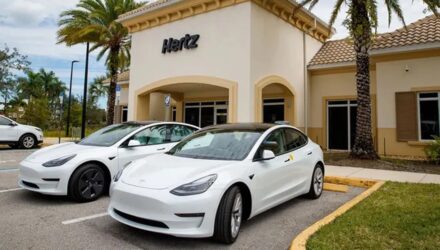 Two Tesla Y Models in front of an Hertz office