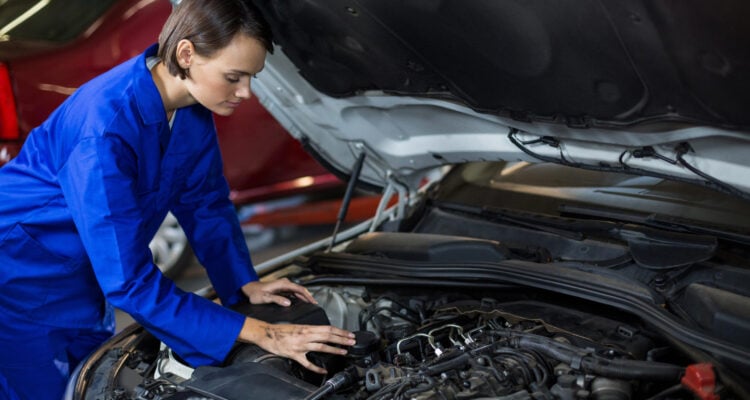 Female Mechanic servicing a car