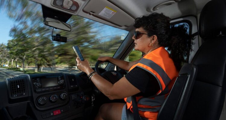 Woman driving while using a mobile phone