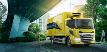 A yellow DAF truck under an underpass