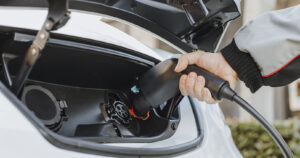 Electric vehicle being plugged in to be charged up