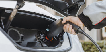 Electric vehicle being plugged in to be charged up