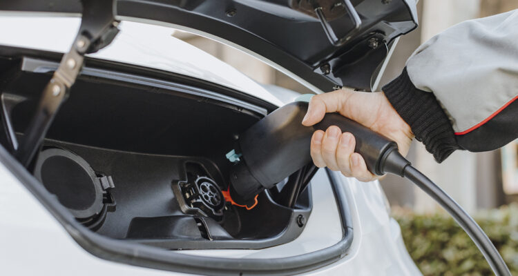 Electric vehicle being plugged in to be charged up