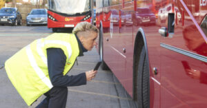Go-Ahead bus driver using Tranzaura app for vehicle checks