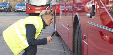 Go-Ahead bus driver using Tranzaura app for vehicle checks
