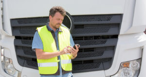 Man using phone in front of lorry