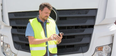 Man using phone in front of lorry