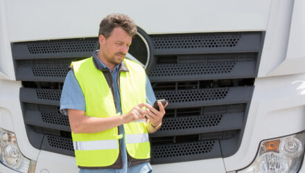 Man using phone in front of lorry