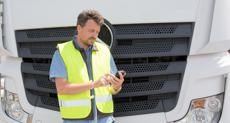 Man using phone in front of lorry