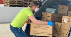 Delivery driver unloading boxes from his van