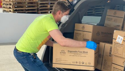 Delivery driver unloading boxes from his van