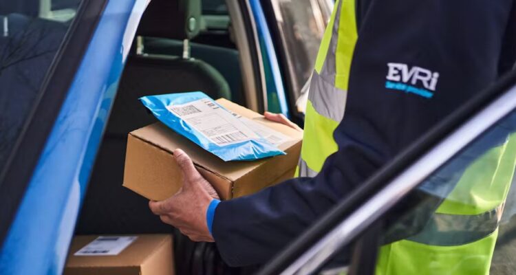 Courer outside blue van holding a box and packet