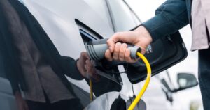 Driver plugging in a charger to an electric van