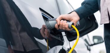 Driver plugging in a charger to an electric van