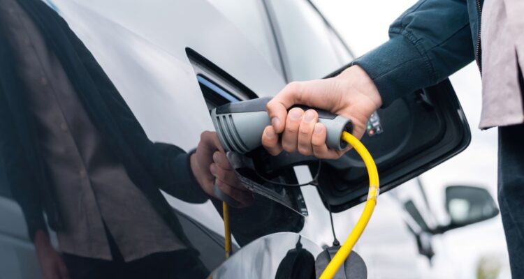 Driver plugging in a charger to an electric van