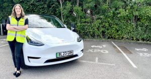 XPO employee with her new electric car