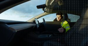 Thatcham Research specialist sitting in a car looking at a laptop