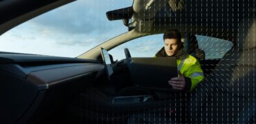 Thatcham Research specialist sitting in a car looking at a laptop