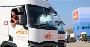 Smiling truck driver in the cab of a Whistl tractor