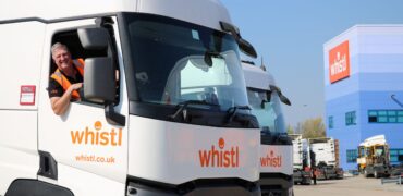 Smiling truck driver in the cab of a Whistl tractor