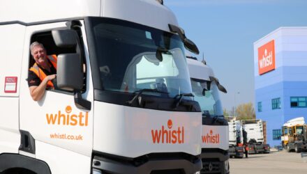 Smiling truck driver in the cab of a Whistl tractor
