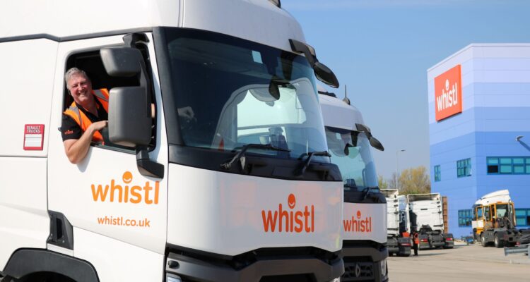 Smiling truck driver in the cab of a Whistl tractor