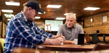 Two HGV drivers chatting over a mug of tea