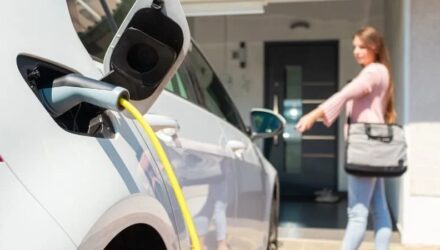 Driver charging her electric car at home