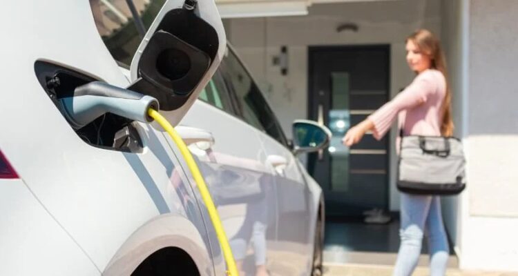 Driver charging her electric car at home