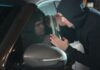 Hooded man looking into a car window