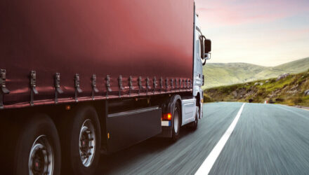 Side view of a red curtainsider lorry